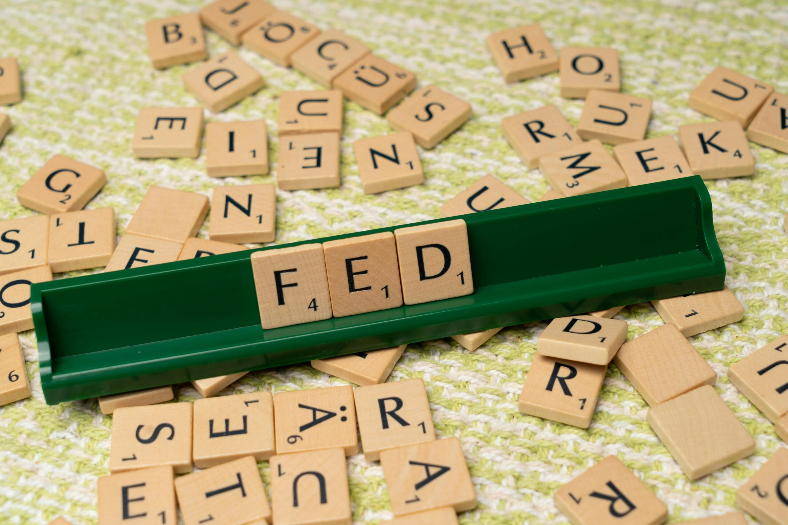 Scrabble letters spelling fed on a green mat