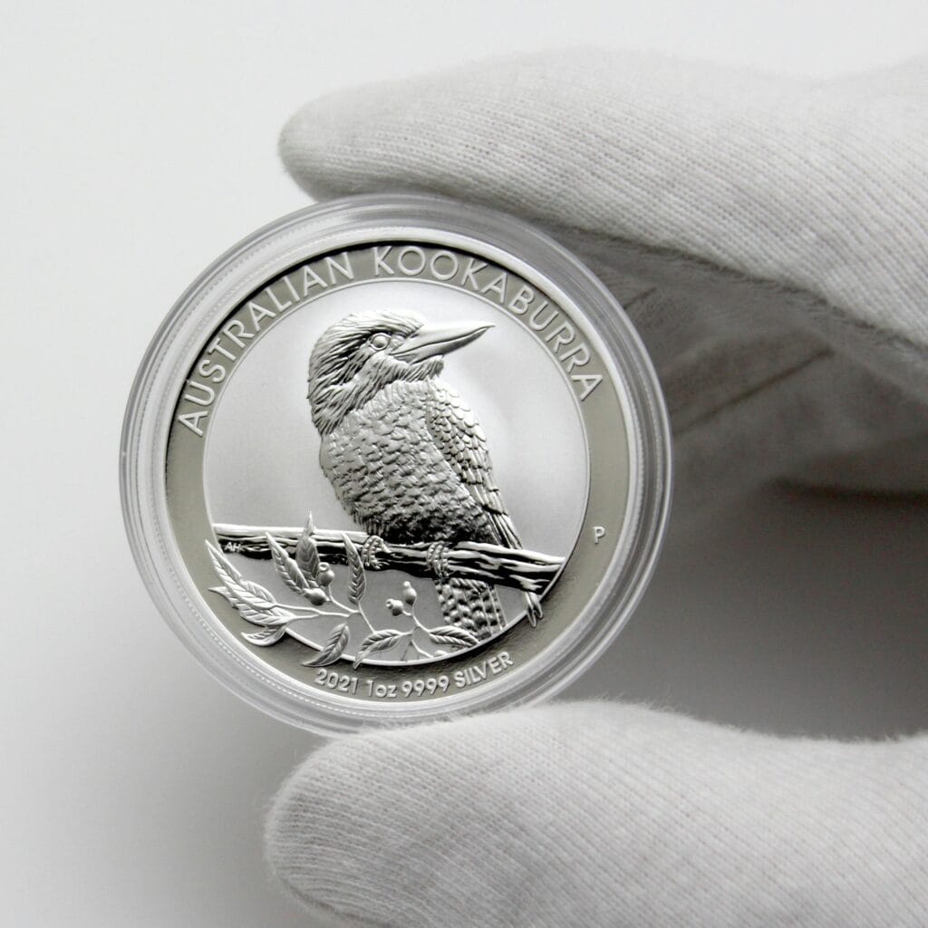 Close-up of Australian Kookaburra silver coin in a gloved hand, showcasing intricate details.