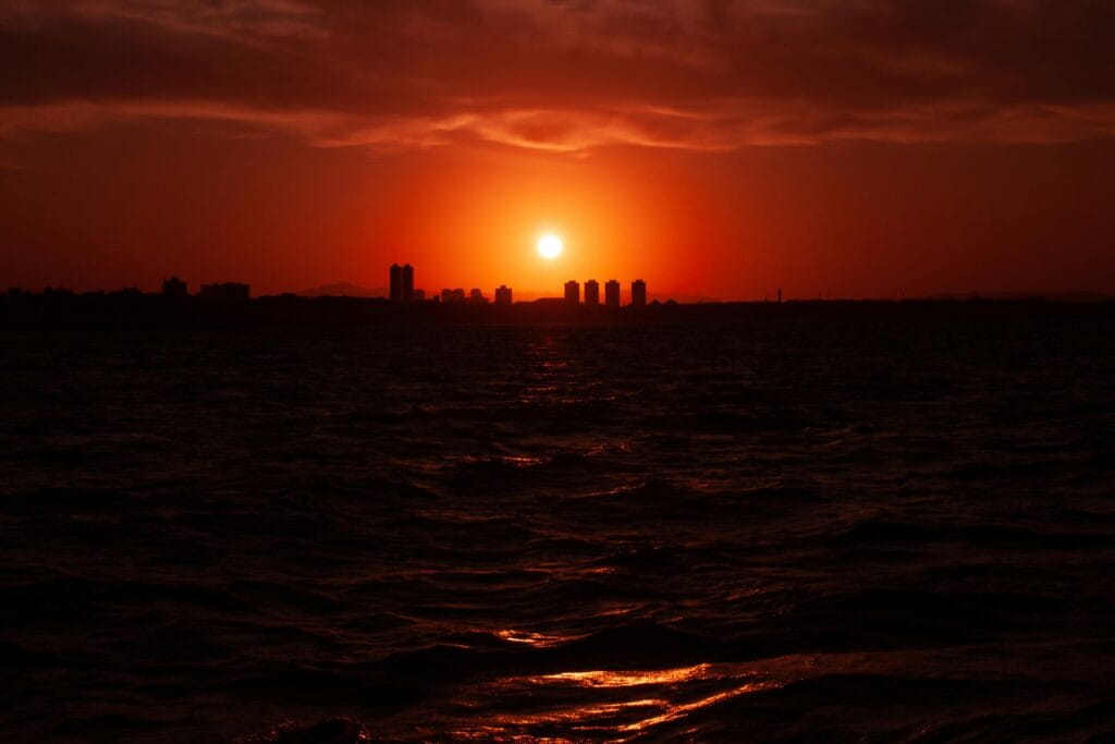 Captivating sunset with a red sky over Fortaleza skyline and sea.